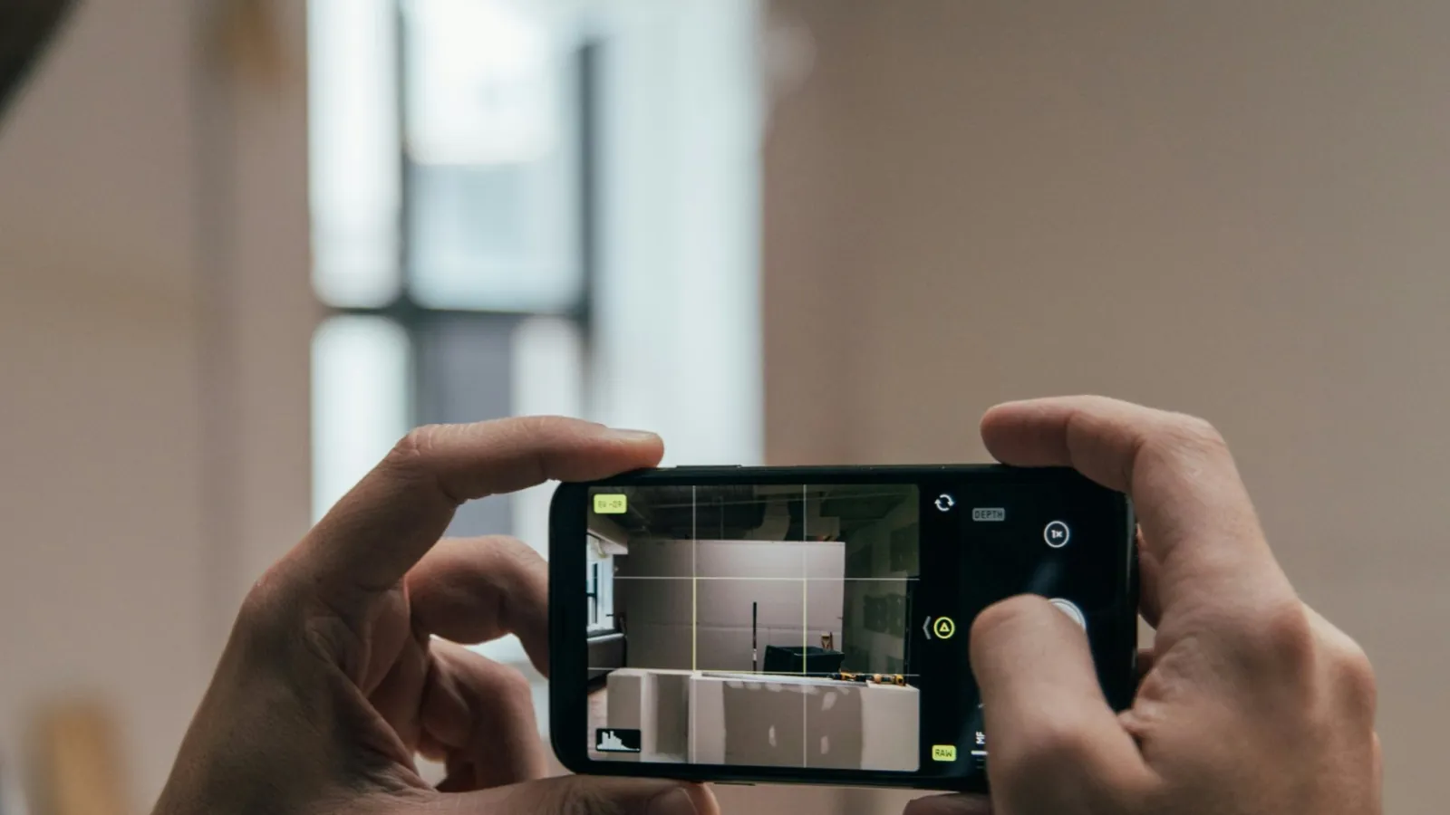 A person filming a room under renovation on a smartphone