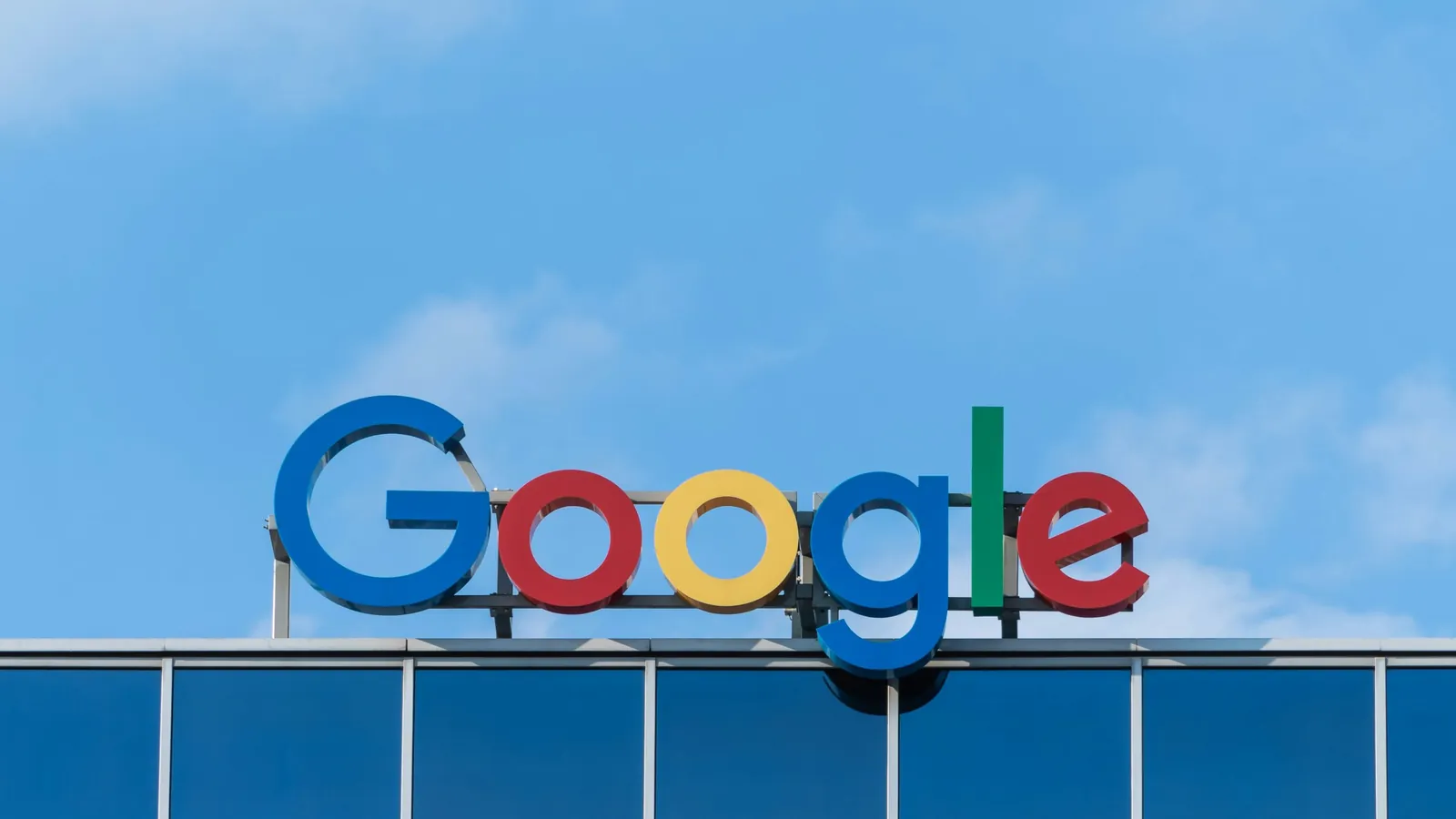 The Google logo on top of an office building against a blue sky